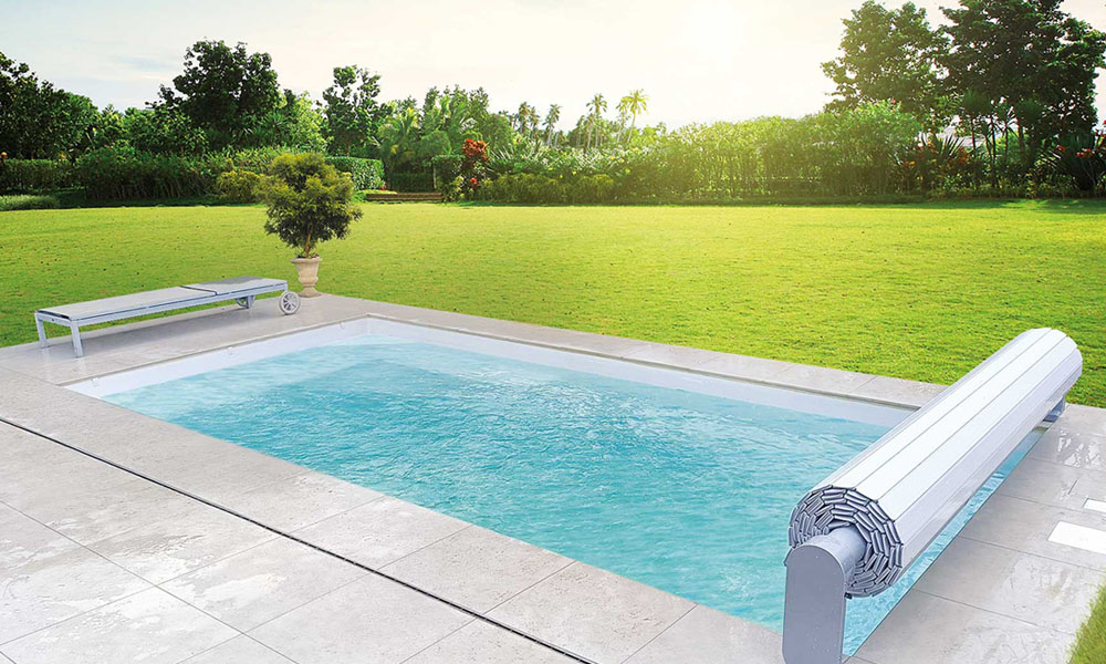 Ein Pool im Garten bei Tageslicht, umgeben von grüner Wiese und Bäumen.