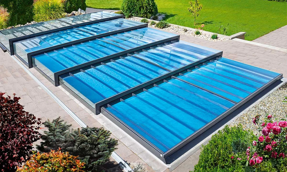 Überdachtes Schwimmbad im Freien mit klaren, blauen Paneelen und umgeben von Pflanzen.